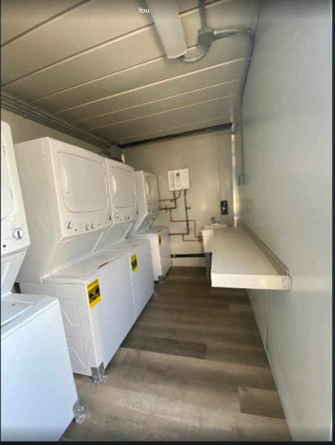 Washing machines and dryers inside a laundry container