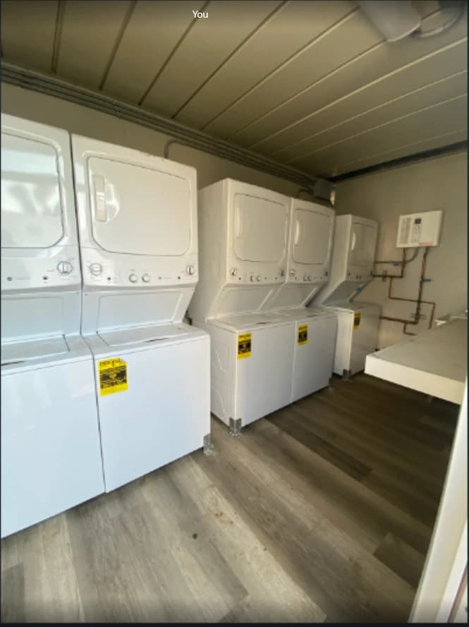 Washing machines and dryers inside a laundry container