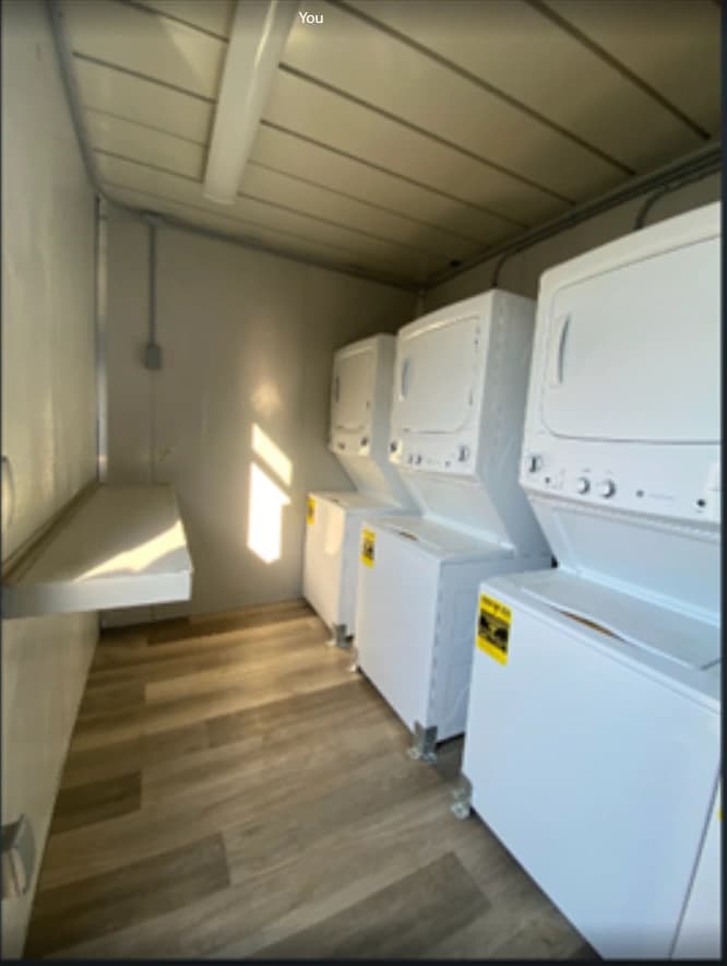 Washing machines and dryers inside a laundry container