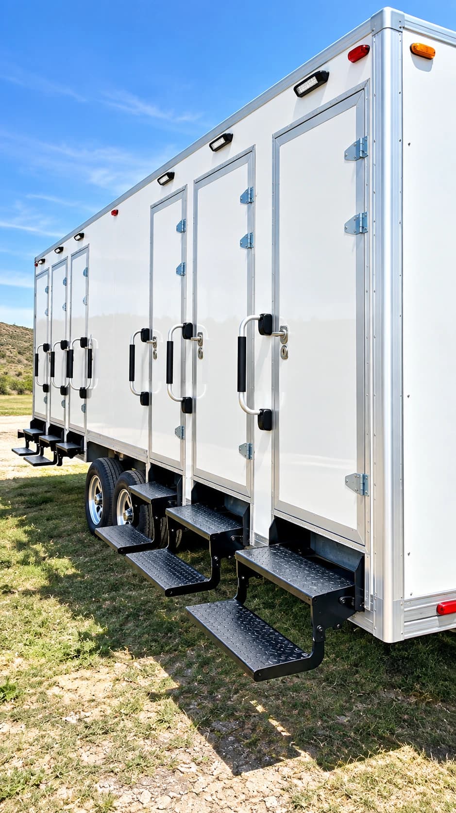 White shower and restroom combination trailer with individual entrance doors and steps