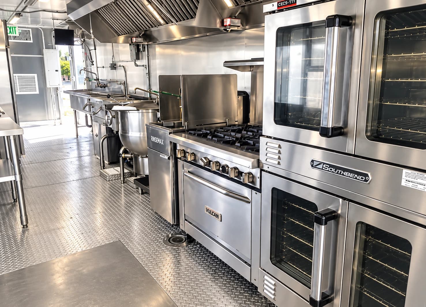 Commercial kitchen trailer interior with a range, ovens and stainless steel work surfaces