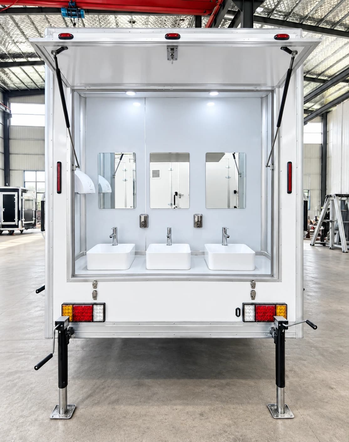 Rear handwashing sinks and mirrors on a shower-facility trailer